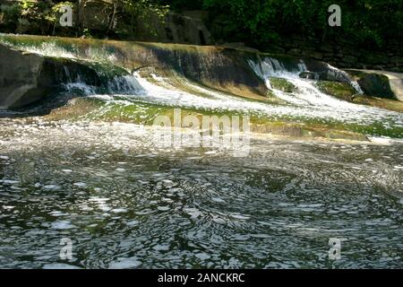 Der Rocky River in Olmsted Falls, Ohio, USA. Schaum auf der Wasseroberfläche am Rand eines Sturzes. Stockfoto