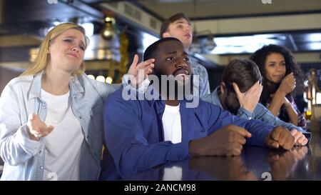 Freunde gemeinsam Sport in bar, verärgert über das verlieren Spiel, enttäuscht. Stockfoto