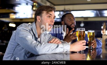 Nervöse männliche Freunde aufmerksam beobachten Sport match Bier trinken, Support Stockfoto