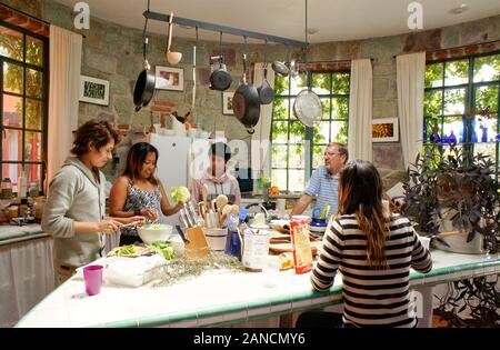Mexikanische Familie kochen in San Miguel de Allende, Mexiko. Mutter und Kinder, Salat und Enchiladas. Stockfoto