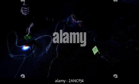 Offiziere mit Taschenlampe Studium Tatort und zur Festsetzung der Zahl der Beweise Stockfoto