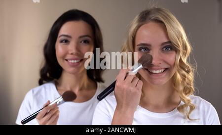 Zwei lächelnde junge Frauen, Abend Make-up und Vorbereitung für Party, Schönheit Stockfoto