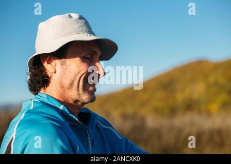 Ein Profilbild eines älteren Mannes. Herbst Berge Hintergrund Stockfoto