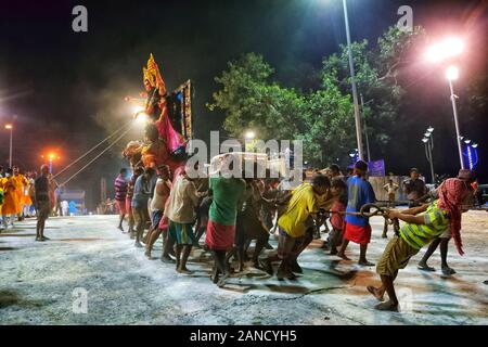 Leute nehmen ein Idol der hinduistischen Göttin Durga am Flußufer zum Eintauchen. Stockfoto