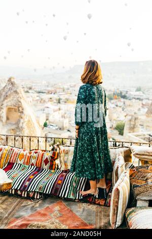 Frau bei Sonnenaufgang mit Heißluftballons steigt in Kappadokien Türkei Stockfoto