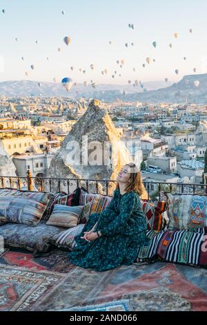 Frau bei Sonnenaufgang mit Heißluftballons in Kappadokien Türkei aufsteigen Stockfoto