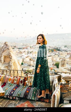 Frau bei Sonnenaufgang mit Heißluftballons steigt in Kappadokien Türkei Stockfoto