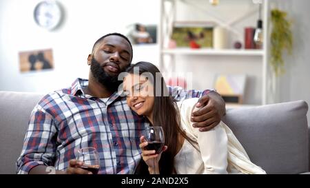 Sweet mixed-Race Paar umarmen und Entspannen mit Wein zu Hause, in der Freizeit Stockfoto