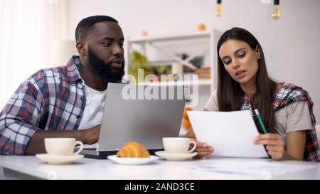 Multirassischen Freiberufler auf Projekt am mit Laptop zuhause arbeitet, Management Stockfoto