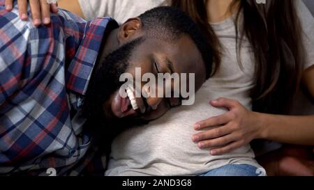 Fröhliche afro-amerikanischer Mann Baby im Bauch, fröhlicher Erwartung hören, Familie Stockfoto