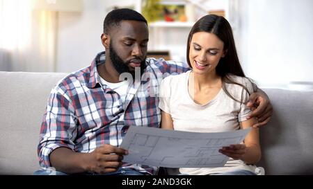 Junge multirassischen Familie am Gebäude planen Suchen, wählen interior design Stockfoto