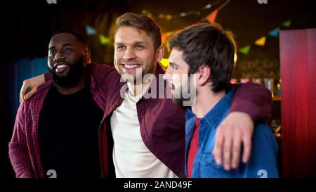 Fröhliche multirassischen Freunde umarmen, feiern Junggesellenabschied in bar, Freizeit Stockfoto