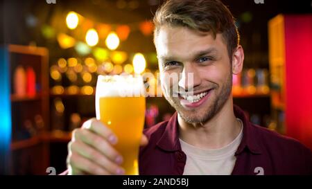 Lächelnd Kerl trinken Licht Lagerbier Geschmack genießen, mens Hobby, Oktober fest Stockfoto