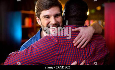Multirassischen Freunde treffen im Pub, Gruß Geste und umarmen, Wochenende Stockfoto