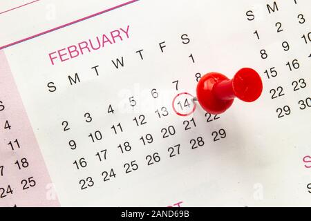 Eine Nahaufnahme auf einen Kalender, der am 14. Februar mit einem Stift und einem roten Kreis Stockfoto