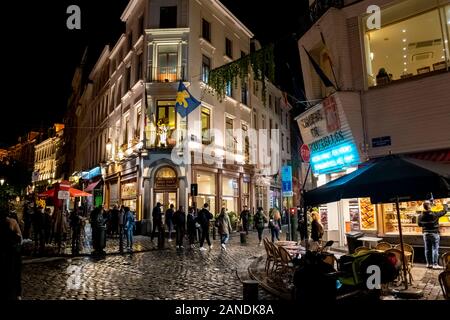 Bis spät in die Nacht in der Altstadt Marktplatz von Brüssel als Touristen und einheimischen Speisen in den Cafes an einem regnerischen Abend. Stockfoto