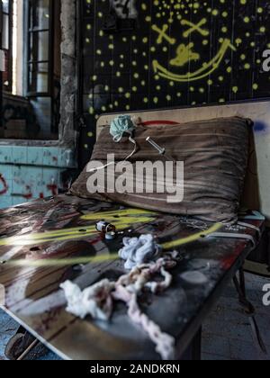 Medikamente verstreut auf einem alten Bett von einem verlassenen Irrenhaus, urbex Fotografie in verlassenen Orten in Italien Stockfoto