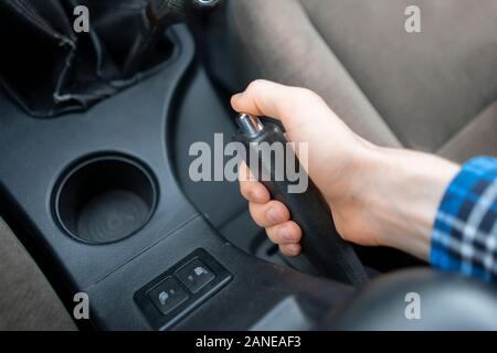 Eine Nahaufnahme mit der Handbremse 7/8 Hand, Fahrer im Auto sitzen Stockfoto