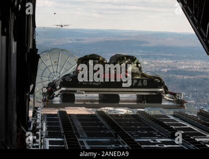 Eine C-130H Hercules auf der 103 Luftbrücke Flügel zugeordnet Tropfen eine schwere Palette über die Drop Zone an Westover Air Reserve Base, Chicopee, Mass Jan. 15, 2020. Piloten aus der 103 flog eine Zwei-ship Formation und führte zum lastenabwurf mit schweren Paletten und Container Systeme, Ausbildung wichtige taktische Lufttransportkapazitäten. (U.S. Air National Guard Foto: Staff Sgt. Steven Tucker) Stockfoto