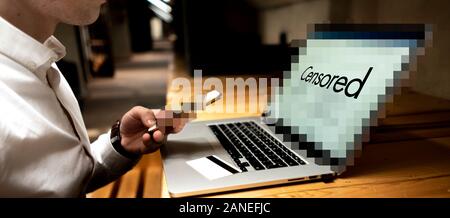 Geschäftsmann mit Mobiltelefon, Notebook und Card, elektronische Zahlung auf seinem Arbeitsplatz f Stockfoto