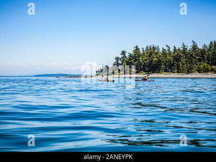 Kajakfahren auf der Nordseite von Orcas Island am North Beach, Washington State, USA. Das ist Mount Baker in der Ferne. Stockfoto