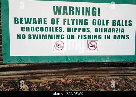 Warnschild, Hinweisschild, Sicherheitshinweise, Vorsicht vor wilden Tieren, fliegenden Golfbällen, Bilharzia in einem Hotelresort in Mpumalanga, Südafrika Stockfoto