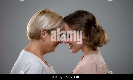 Erwachsene Tochter und Mutter berühren Stirnen suchen, Familie Liebe Stockfoto