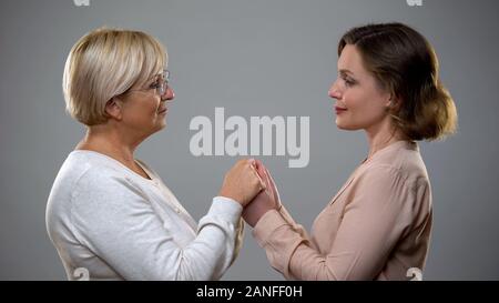 Reife Mutter und erwachsene Tochter, Hände halten, Nähe suchen Stockfoto
