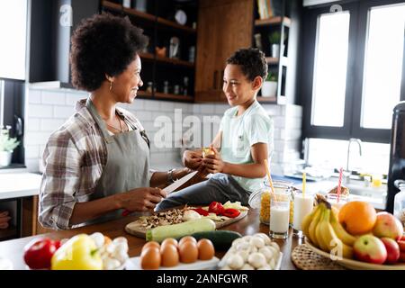 Glückliche Mutter und Kinder in der Küche. Gesundes Essen, Familie, kochen Konzept Stockfoto