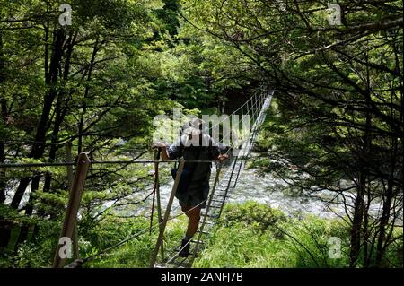 Ein Draht Drehbrücke geht über einen Fluss in Neuseeland Stockfoto