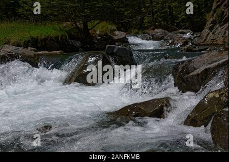 Wasser sprudelt zwischen Felsbrocken auf seinen Kurs auf dem Fluss Stockfoto