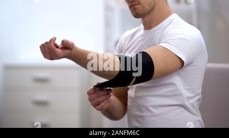 Junge männliche Anwendung Ellenbogen gepolstert Orthese, Orthopädie und Physiotherapie, Gesundheit Stockfoto