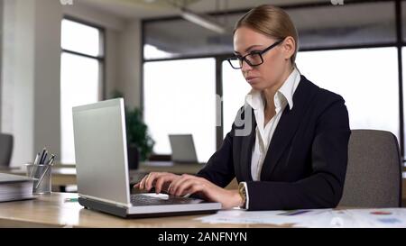 Serious Business Frau Tippen auf Laptop, bei der Arbeit an komplizierten Projekt, Job Stockfoto