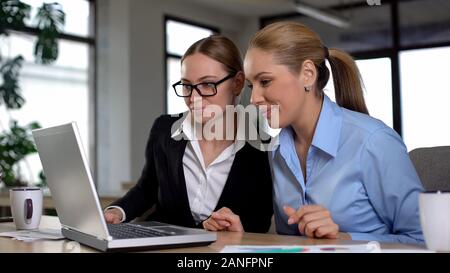 Business Damen beobachten, lustige Video auf Laptop im Büro, in Pause von der Arbeit Stockfoto
