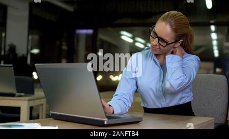 Frau mit Nackenschmerzen, Gefühl während der Nachtschicht müde, stressigen Job Stockfoto