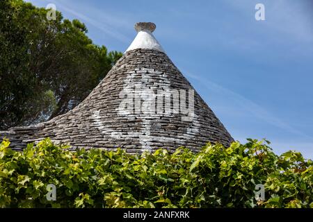 Weinreben auf dem Stein Dach von Trulli in Alberobello, Italien. Der Baustil ist spezifisch für die murge Bereich der italienischen Region ein Stockfoto