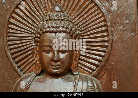 Nahaufnahme eines in Holz geschnitzte Buddha Kopf mit einer mystischen Aura um seinen Kopf herum. An der Nepalesischen Frieden Pagode in Brisbane, South Bank Parklands entfernt Stockfoto