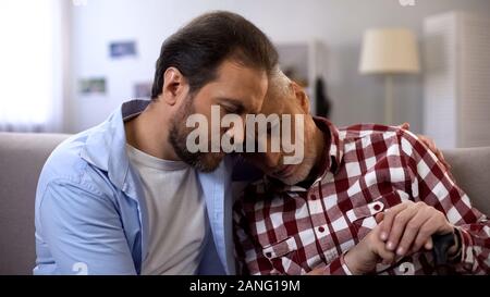 Junger Mann umarmen und trösten gedrückt alten Vati, leiden Melancholie, Verlust Stockfoto