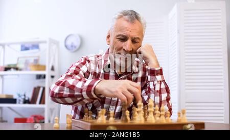 Gerne älterer Mann spielt Schach allein, Ausbildung für Schach, matt Stockfoto
