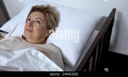 Sorgen ältere Patienten liegen im Krankenbett und um das Suchen, Alzheimers Krankheit Stockfoto