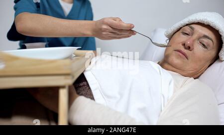 Unheilbar kranke Frau mit Kompresse auf Stirn Verweigerung von hospiz Brei Stockfoto