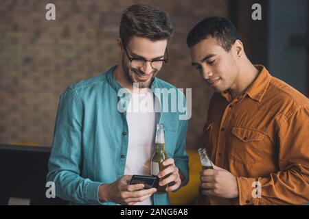 Angenehme glücklicher Mann trinken mit seinem Freund Stockfoto