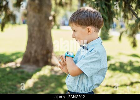 Kleiner Junge mit Smart watch mit Mutter. Smartwatch für Baby Sicherheit. Kind Lernen der neuen Technologie. Mutter und Sohn, die miteinander sprechen, durch Stockfoto