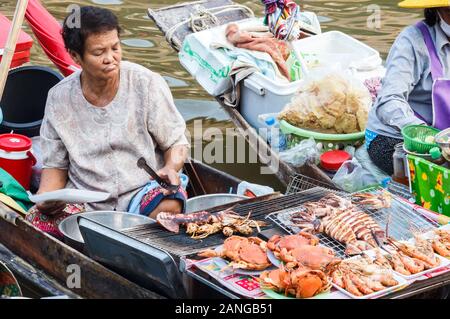 Amphawa, Thailand - 6. November 2015; Seaood Anbieter im Boot auf dem schwimmenden Markt. Der Markt ist jedes Wochenende statt. Stockfoto