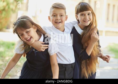 Portrait von begeistert Grundschüler auf dem Spielfeld in den Pausen. Glückliche Kinder Mädchen und jungen Freund Student an der Volksschule. Stockfoto