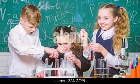 Die Fokussierung auf die Arbeit. Kleine Kinder im Labor. Studenten, Biologie Experimente mit Mikroskop. Labor Mikroskop. Tag der Kinder. Chemie Mikroskop. Kleine Kinder lernen die Chemie in der Schule lab. Stockfoto