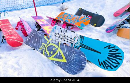 Bunte Snowboards, die auf Schnee im Cairngorm Mountain Ski Center, Cairngorms National Park, Scottish Highlands, in der Nähe von Aviemore, Schottland UK, gestapelt sind Stockfoto