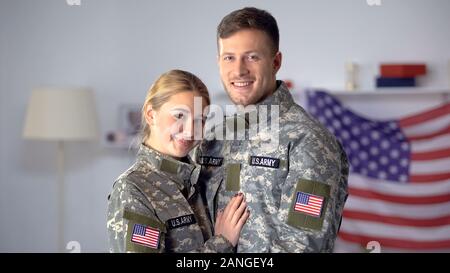 Glückliches Paar der amerikanischen Soldaten, die sich umarmen und lächelnd auf Kamera, stolze Patrioten Stockfoto