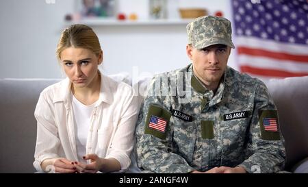 Paar amerikanischer Soldat und seine Frau saß auf dem Sofa, Bruchgefahr umgekippt Stockfoto