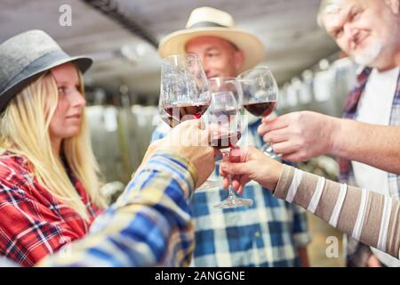 Gruppe von Winzern Toasten mit Rotwein zusammen in der Weinkellerei Stockfoto